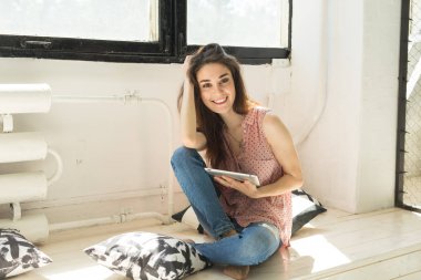 İnsanlar, teknoloji ve iç kavramı - yastık tablet bilgisayarınızla ile katta oturan mutlu genç kadın