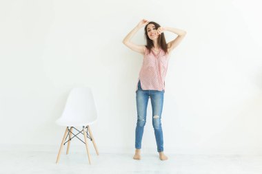 Gülümseyen genç esmer kadın beyaz odada dans tam uzunlukta portresi