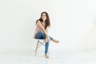 insanlar, güzellik ve moda kavramı - kopya alanı ile beyaz arka plan üzerinde izole sandalye poz genç esmer kadın