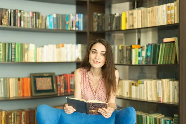 Persone, istruzione e concetto di conoscenza - Donna che legge libro in biblioteca — Foto Stock