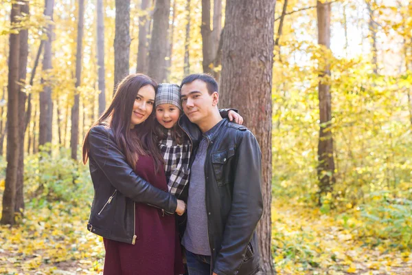 Parenthood, fall and people concept - young family happy in autumn park