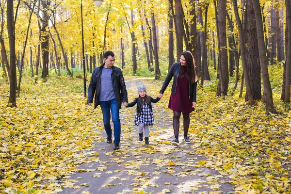 Parks, nature and family concept - Happy family walking in autumn park — Stock Photo, Image