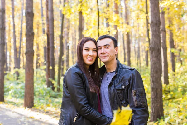 Concepto de personas, familia y ocio - pareja joven divirtiéndose en el parque de otoño — Foto de Stock