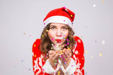 Tatil, Noel ve insanlar kavramı - Noel Baba kostüm konfeti üzerinde beyaz arka plan üzerinde güzel ve genç kadın