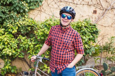 Mutlu genç erkek tutun Bisiklet arka plan yeşil