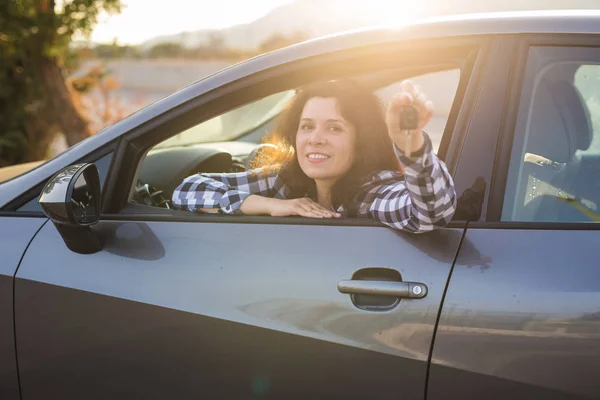 Nové auto, nákupu a řidič koncept - mladá žena zobrazeno klíče v autě — Stock fotografie