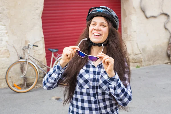 배경 자전거와 레드 도어에 선글라스를 들고 젊은 아름 다운 여자 — 스톡 사진