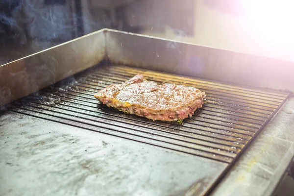 Mat och matlagning koncept - på nära håll av en biff på grillen — Stockfoto