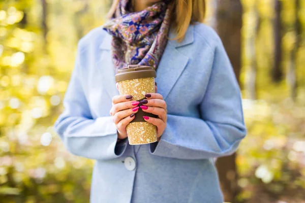 Autumn, drinks and people concept - Cup of hot drink in womans hand