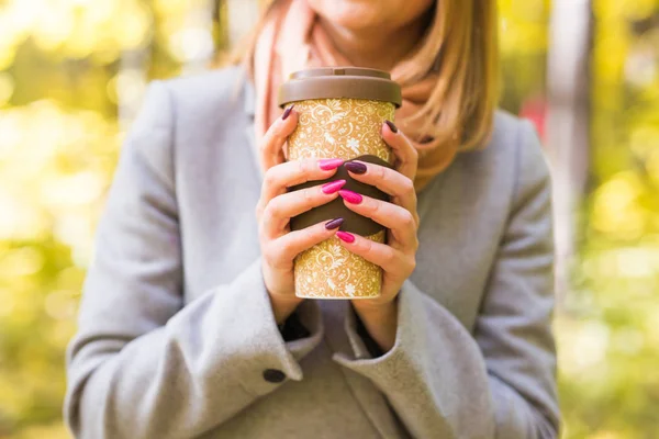 Autumn, Doğa ve insan kavramı - gri paltolu bir fincan kahve tutan kadının yakın — Stok fotoğraf