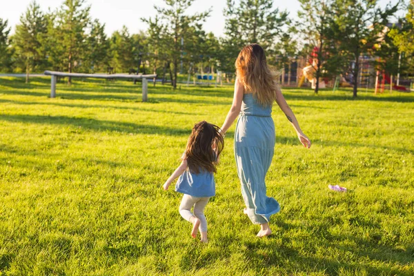 Conceito de família e criança - Mãe e filha caminhando no parque e desfrutando da bela natureza . — Fotografia de Stock