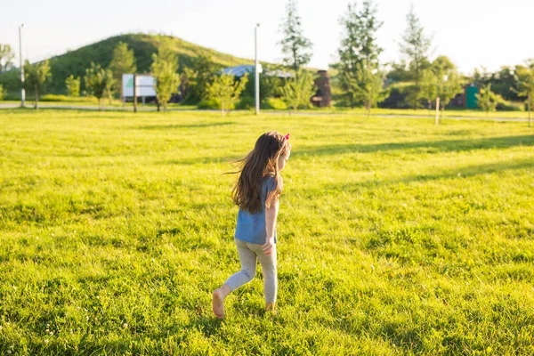 Pequena menina feliz se divertindo em um parque de verão . — Fotografia de Stock