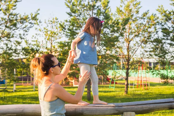 Концепція сім'ї та дитини - мати та дочка гуляють та грають у парку та насолоджуються прекрасною природою . — стокове фото