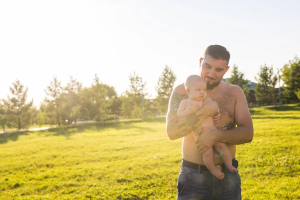 Buon padre che tiene in braccio il bambino sulla natura. Concetto di famiglia felice, giorno di padri e bambino . — Foto Stock