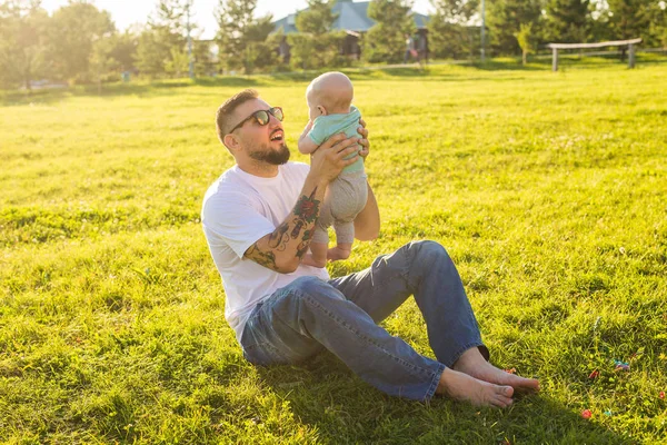 Heureux père tenant bébé fils sur la nature. Concept de famille heureuse, fête des pères et des enfants . — Photo