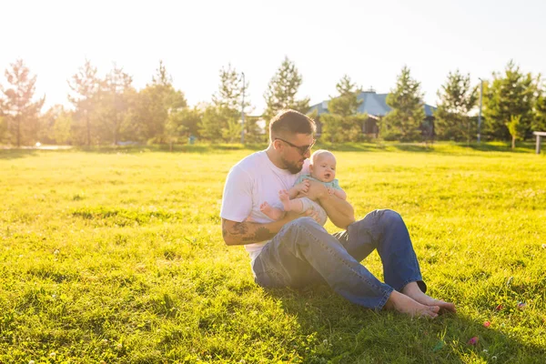 Heureux père tenant bébé fils sur la nature. Concept de famille heureuse, fête des pères et des enfants . — Photo