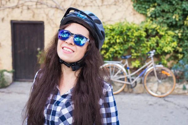 헬멧과 선글라스 backgound 자전거와 스트리트 포즈 행복 한 여자 — 스톡 사진