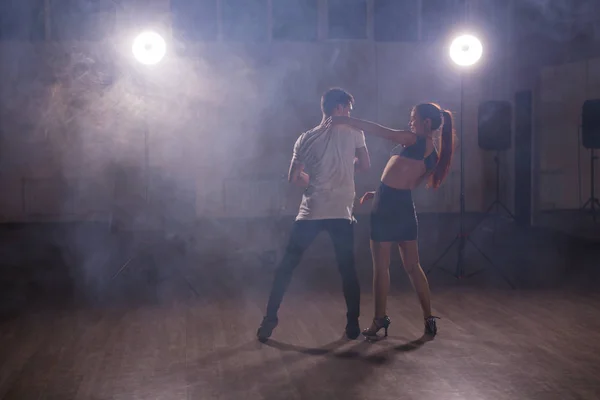 Behendig dansers het uitvoeren in de donkere kamer onder het concert licht en rook. Sensuele paar uitvoeren van een artistieke en emotionele hedendaagse dans — Stockfoto