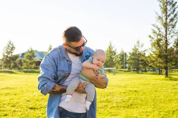 Feliz padre sosteniendo al bebé. Concepto de familia feliz, día del padre y el niño . — Foto de Stock