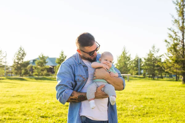 Feliz padre sosteniendo al bebé. Concepto de familia feliz, día del padre y el niño . — Foto de Stock