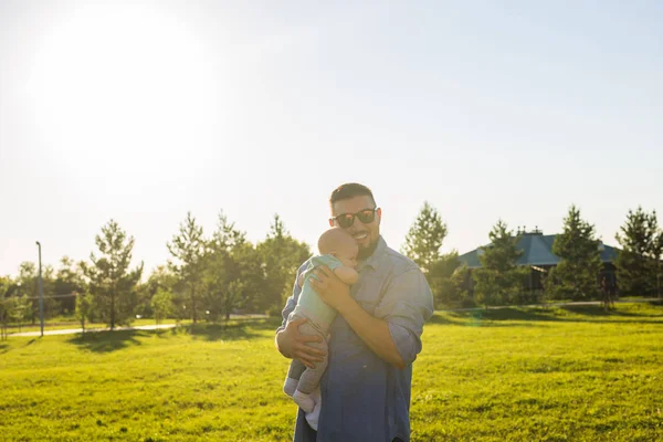Happy father holding baby son. Concept of happy family, fathers day and child. — Stock Photo, Image