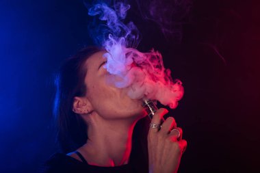 Neon kırmızı ve mavi genç kadın portresi ile vape ya da e-sigara duman