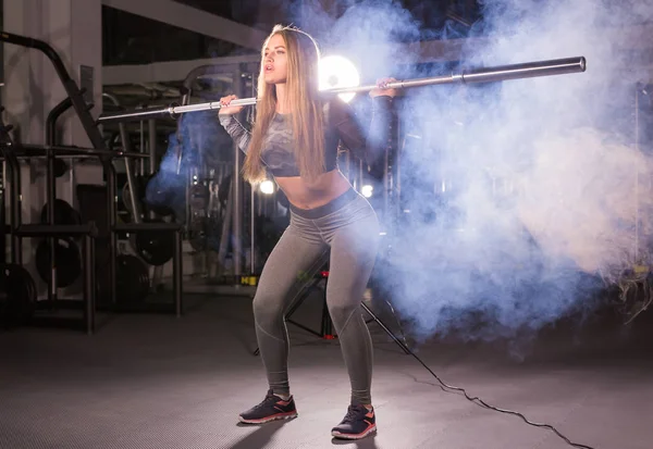 Deporte, fitness, entrenamiento y concepto de felicidad - mujer deportiva con barra en el gimnasio —  Fotos de Stock