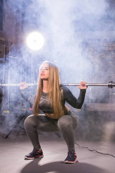 Deporte, fitness, entrenamiento y concepto de felicidad - mujer deportiva con barra en el gimnasio — Foto de Stock
