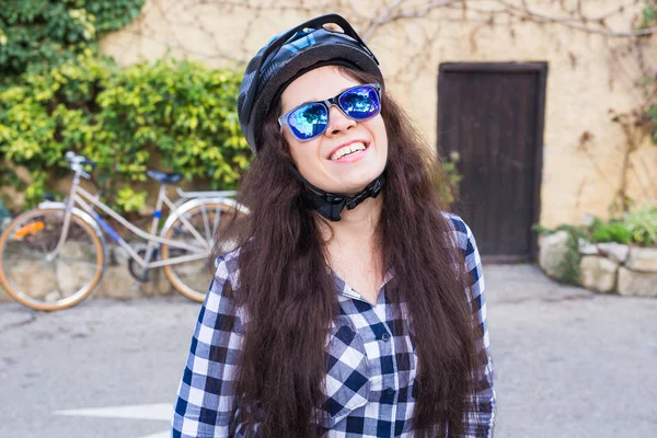 헬멧과 선글라스 배경 자전거와 골목에 위치와 웃는 여자 — 스톡 사진
