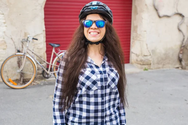 선글라스와 빨간 배경 문 및 자전거 헬멧 쾌활 한 여자 — 스톡 사진