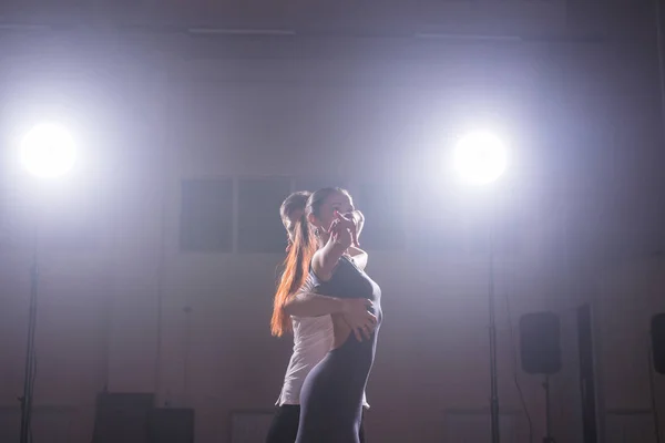 Geschickte Tänzer, die im dunklen Raum unter dem Licht und Rauch des Konzerts auftreten. sinnliches Paar, das einen künstlerischen und emotionalen zeitgenössischen Tanz aufführt — Stockfoto