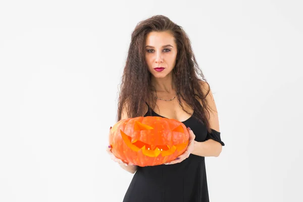 Smiling brunette woman in halloween makeup posing with carved pumpkin — Stock Photo, Image