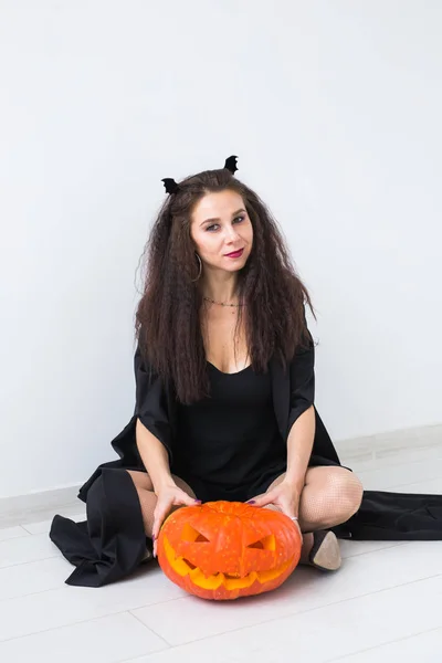Halloween und Feiertage - Hexenfrau mit Jack-olantern-Kürbis Stockbild