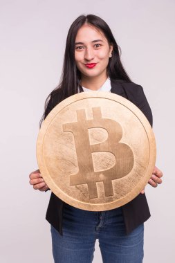 Kripto para birimi, web para ve blockchain kavramı - büyük bitcoin beyaz arka plan üzerinde tutan Asyalı kadın