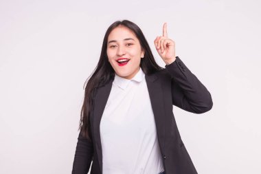 Resmi kıyafetler beyaz arka plan üzerinde parmak gösteren yeni bir fikir ile Asyalı Kız portresi.