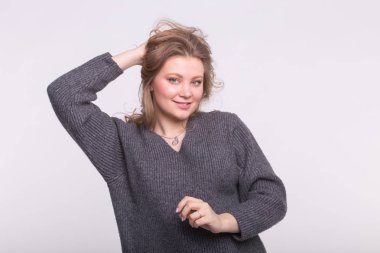 Artı-size kadın modeli ile saç beyaz arka plan üzerinde gri kazak giymiş elinde