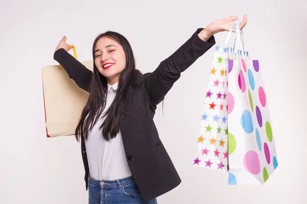 Hermosa morena mujer asiática con labios rojos levantando bolsas de compras en fondo blanco . — Foto de Stock