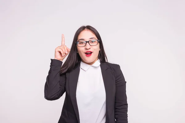 Mimik und Personenkonzept - junge asiatische Frau mit Brille zeigt Ideengeste vor weißem Hintergrund. — Stockfoto