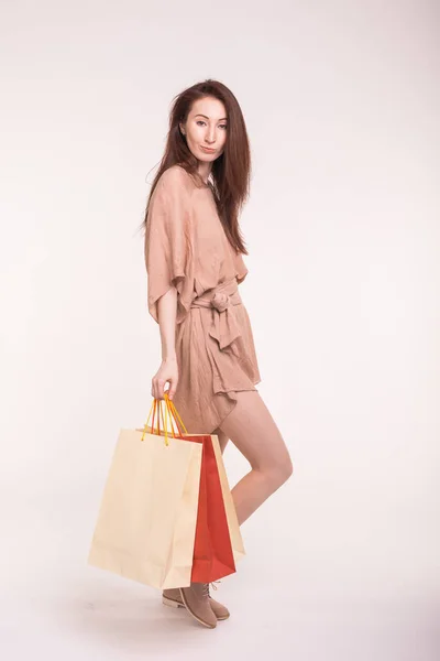 Концепция розничной торговли и продажи - улыбающаяся азиатка в платье с большим количеством сумок для покупок на белом фоне — стоковое фото