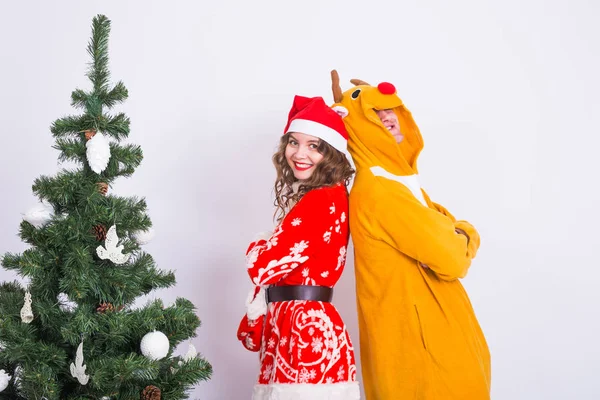Les gens, la famille et le concept de Noël - beau couple en costumes de Noël près de l'arbre de Noël sur fond blanc . — Photo