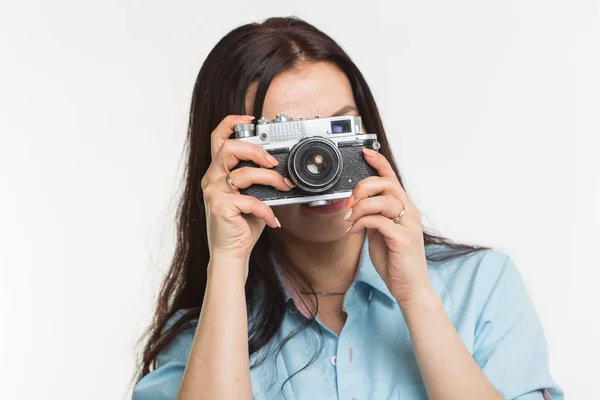 Photographer, hobby and people concept - Young brunette woman with retro camera on white background — Stock Photo, Image