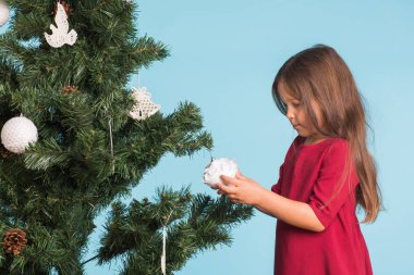 Noel, çocukluk ve insanlar kavramı - küçük kız Noel ağacı süsleme