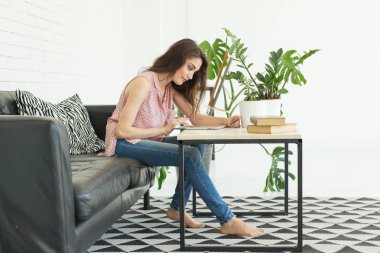 Teknoloji ve insan kavramı - tablet ile beyaz masada oturan güzel kız