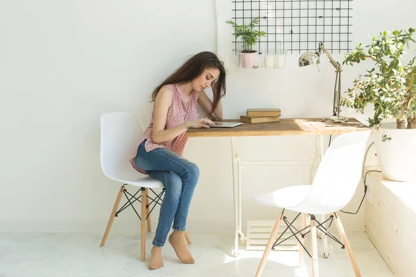 Technologies, concept de personnes - jeune femme assise sur une chaise et regardant l'ordinateur portable ou surfant sur le net — Photo