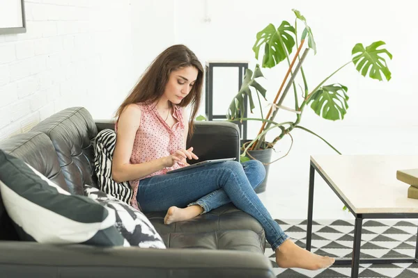 Persone, concetto di interni e tempo libero - felice giovane donna con tablet pc sdraiato sul divano — Foto Stock