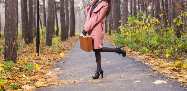 Autumn, fashion, people concept - close up of woman with brown retro suitcase walking through the autumn park — Stock Photo, Image