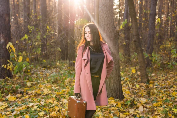 Otoño, moda, concepto de personas - mujer con maleta retro marrón caminando por el parque de otoño — Foto de Stock