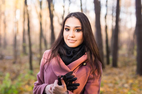 Mensen, seizoen en stijl concept - mooie jonge vrouw die lacht in herfst park — Stockfoto