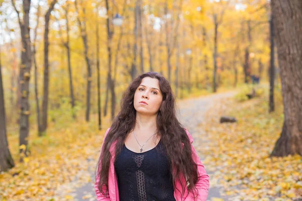 Portrait d'une belle et rêveuse jeune femme aux longs cheveux ondulés dans le parc d'automne — Photo