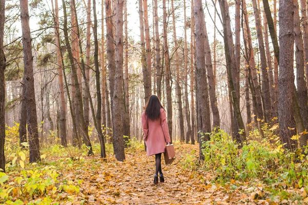 Achteraanzicht van stijlvolle jongedame met retro koffer wandelen in de herfst park — Stockfoto